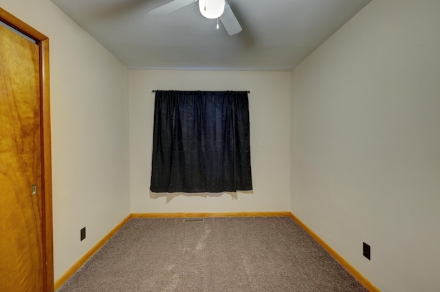 carpeted spare room with a ceiling fan, visible vents, and baseboards