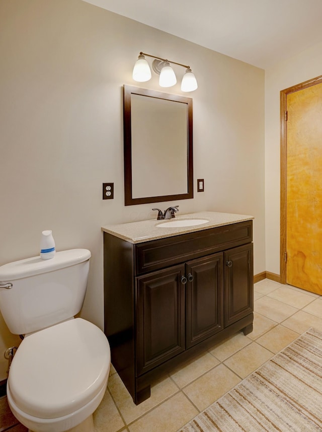 bathroom featuring baseboards, vanity, toilet, and tile patterned floors