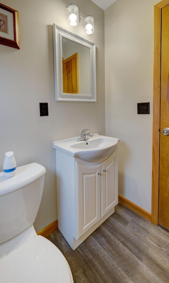 bathroom featuring vanity, wood finished floors, toilet, and baseboards