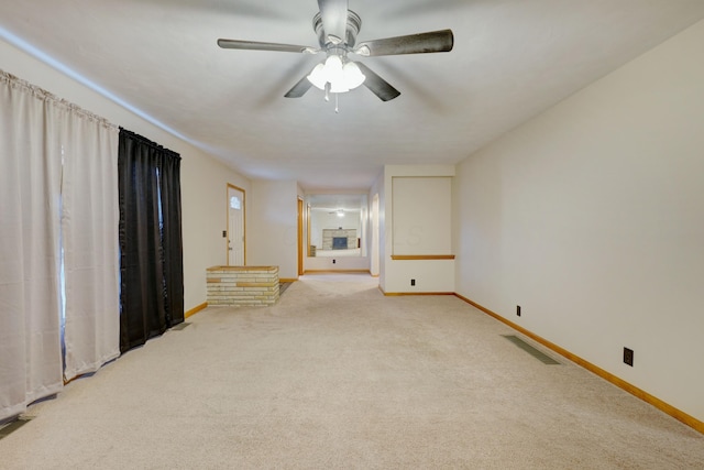 empty room with a ceiling fan, light colored carpet, visible vents, and baseboards