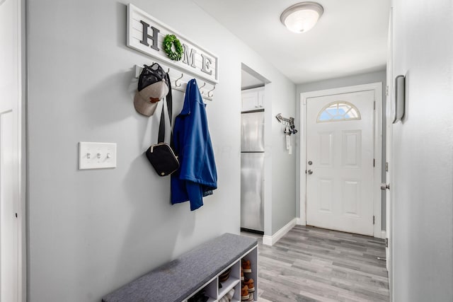 mudroom featuring light wood-style floors and baseboards