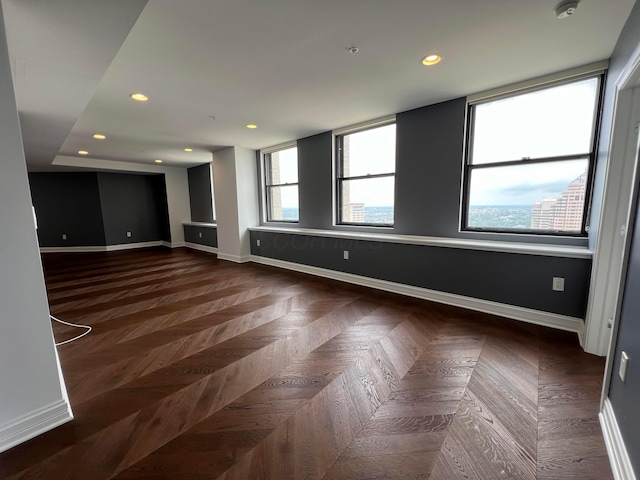 spare room featuring a view of city, recessed lighting, and baseboards