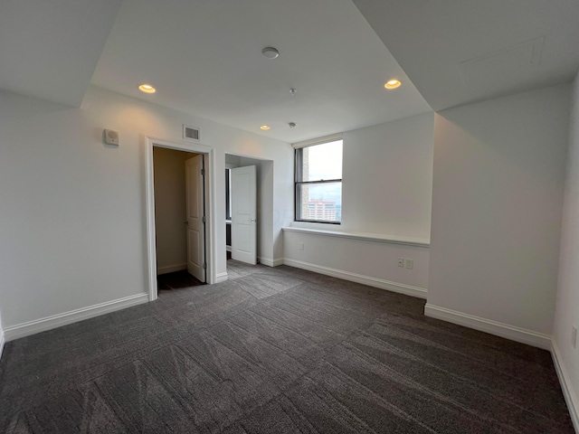 unfurnished room featuring recessed lighting, visible vents, dark carpet, and baseboards