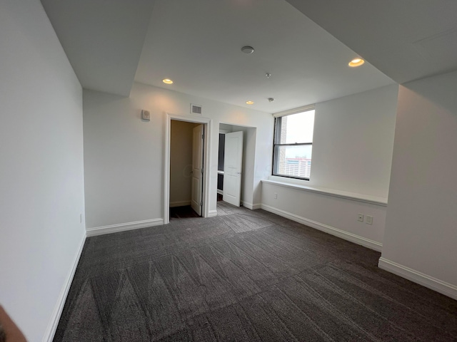 interior space featuring recessed lighting, visible vents, baseboards, and dark colored carpet