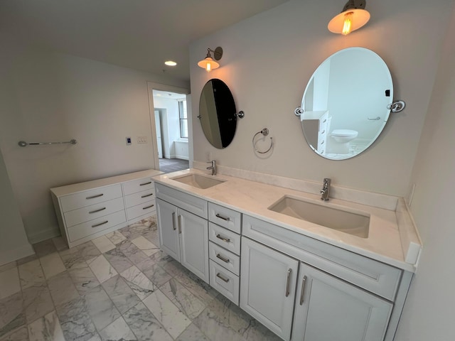 bathroom featuring double vanity, marble finish floor, a sink, and recessed lighting