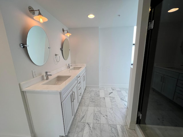 bathroom with recessed lighting, marble finish floor, a sink, and double vanity