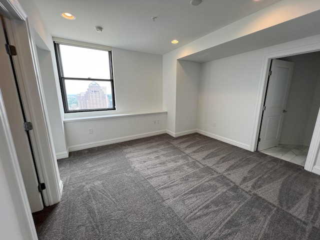 unfurnished bedroom with baseboards, dark colored carpet, and recessed lighting