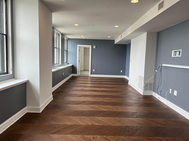 corridor with baseboards, visible vents, and recessed lighting