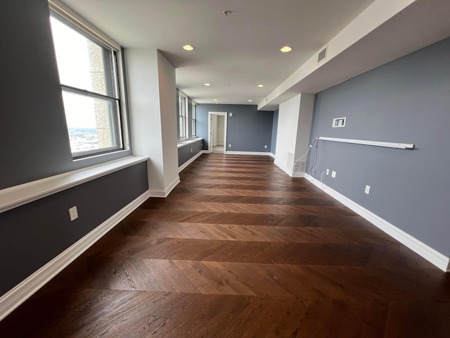 empty room featuring parquet floors, recessed lighting, visible vents, and baseboards