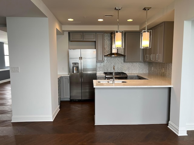 kitchen featuring hanging light fixtures, a peninsula, light countertops, and stainless steel fridge with ice dispenser