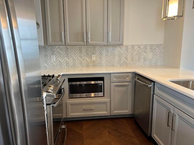 kitchen with stainless steel appliances, gray cabinets, and light countertops