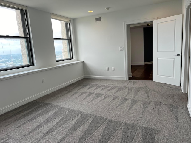 carpeted spare room featuring recessed lighting, visible vents, and baseboards