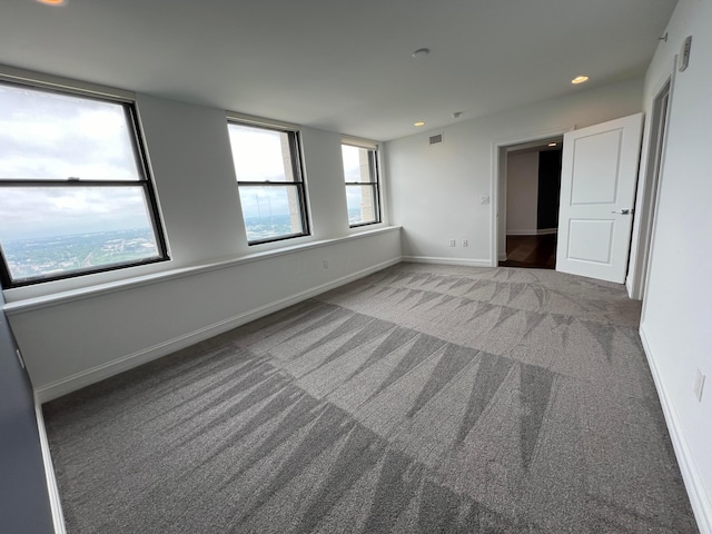 unfurnished room featuring carpet floors, visible vents, baseboards, and recessed lighting