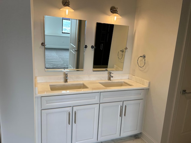 bathroom featuring double vanity, a sink, and baseboards