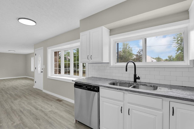 kitchen with plenty of natural light, decorative backsplash, dishwasher, light wood-style flooring, and a sink