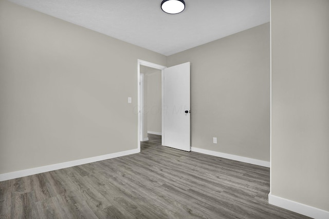 unfurnished room featuring wood finished floors and baseboards