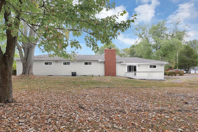 back of property with central AC and a chimney