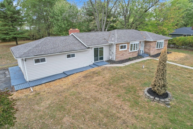 view of front of home featuring a chimney, a front lawn, and roof with shingles