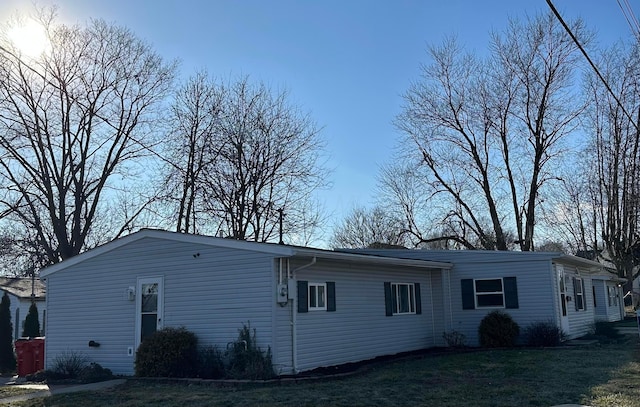 view of side of home with a yard