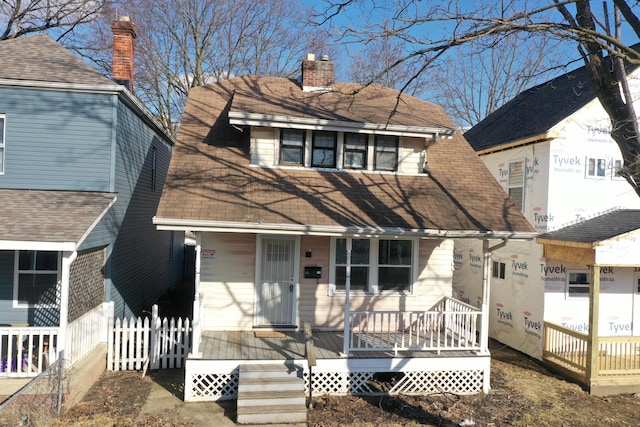 view of front of home with a chimney and fence