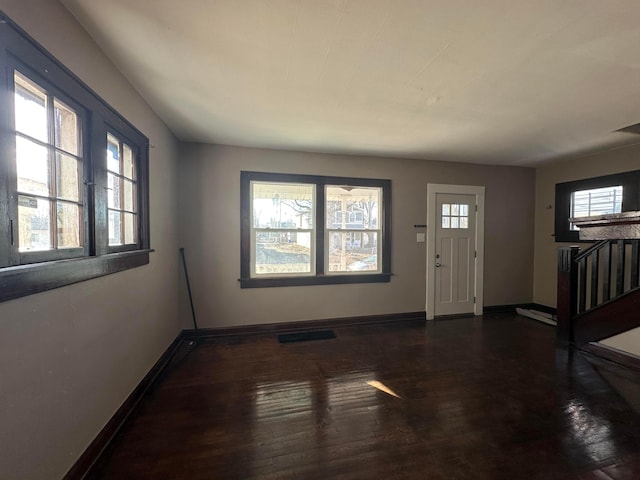 entrance foyer with dark wood-type flooring and baseboards