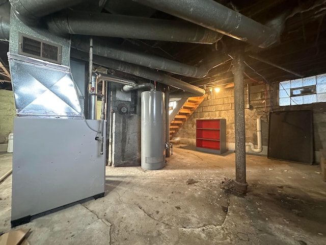 unfinished basement featuring heating unit, stairs, and gas water heater