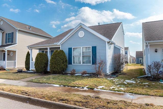 view of front of home with a shingled roof and a front yard