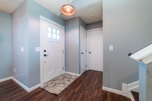 entryway featuring dark wood-style floors, stairway, a textured ceiling, and baseboards