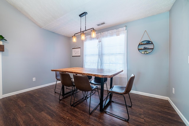 dining room featuring baseboards, a textured ceiling, visible vents, and dark wood-type flooring