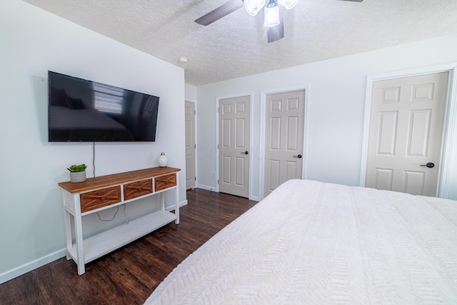 bedroom featuring dark wood-style flooring, ceiling fan, a textured ceiling, and baseboards