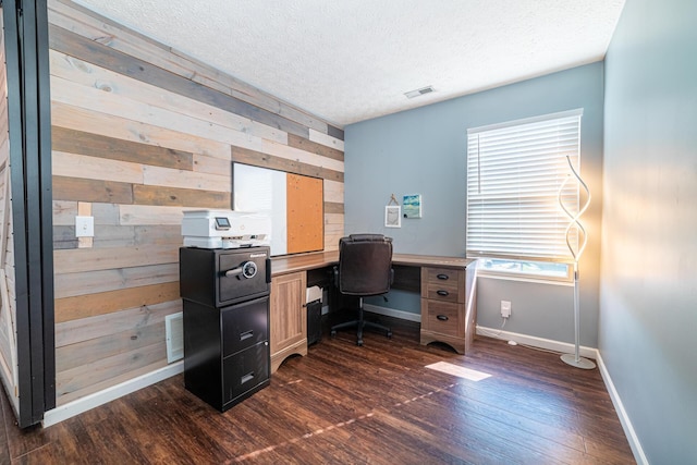 office area featuring baseboards, visible vents, dark wood-style floors, a textured ceiling, and wood walls