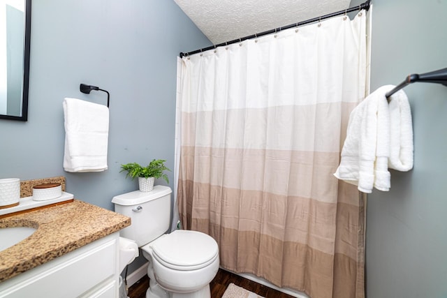 full bath featuring a textured ceiling, curtained shower, toilet, wood finished floors, and vanity