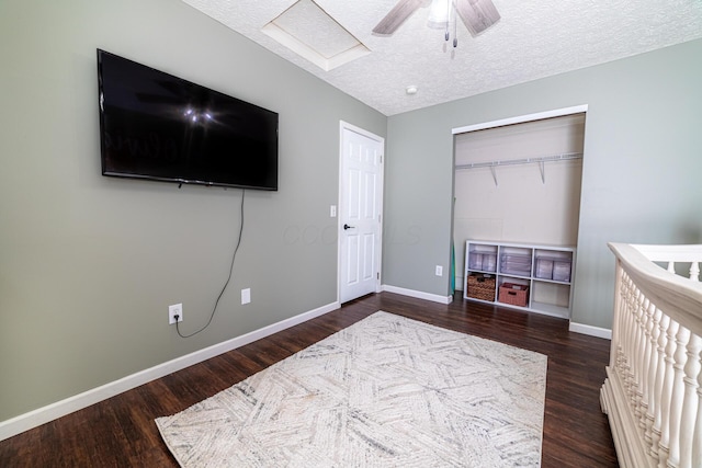 bedroom featuring ceiling fan, baseboards, dark wood finished floors, and a textured ceiling