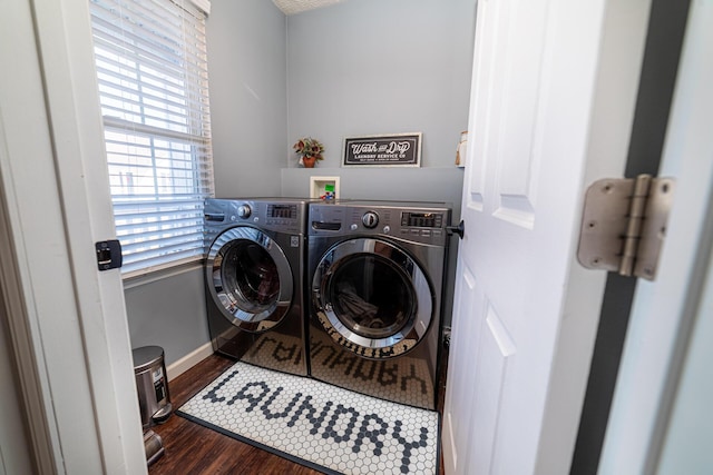 clothes washing area with dark wood-style floors, washer and dryer, laundry area, and baseboards