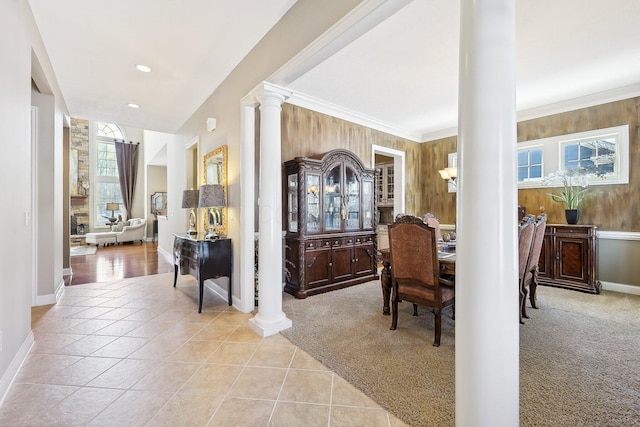 entryway featuring light carpet, light tile patterned floors, ornamental molding, and ornate columns