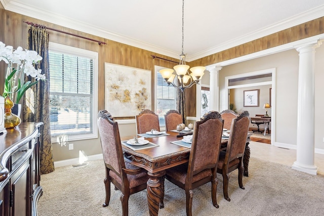 dining area featuring light carpet, ornamental molding, decorative columns, and an inviting chandelier