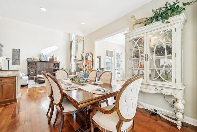 dining area featuring wood-type flooring, a fireplace, baseboards, and recessed lighting