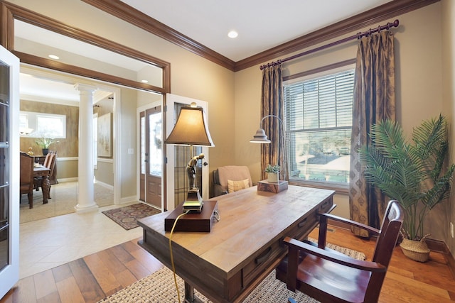 office featuring baseboards, ornamental molding, light wood-style flooring, and ornate columns