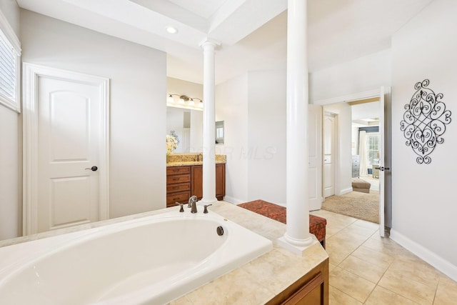 bathroom featuring a garden tub, vanity, decorative columns, and tile patterned floors