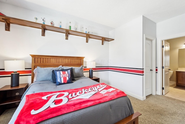 carpeted bedroom featuring baseboards and connected bathroom