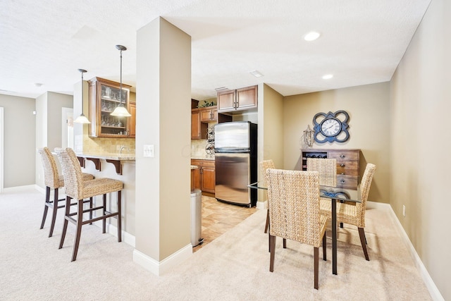 dining area featuring recessed lighting, light carpet, and baseboards