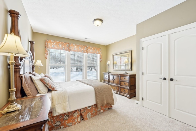 bedroom featuring a textured ceiling, a closet, and light colored carpet