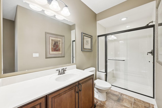 bathroom with toilet, a shower stall, tile patterned flooring, and vanity