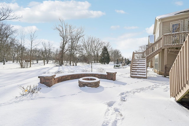 yard layered in snow with an outdoor fire pit and stairs