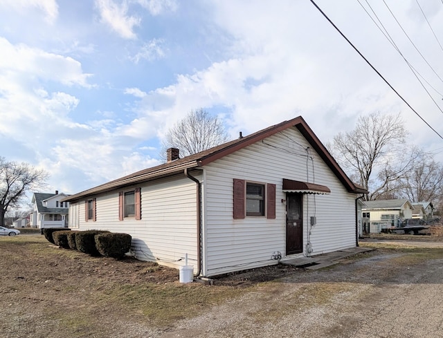 exterior space featuring driveway and a chimney