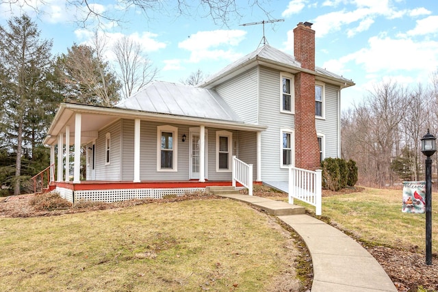 view of front of property featuring metal roof, a porch, a front lawn, a standing seam roof, and a chimney