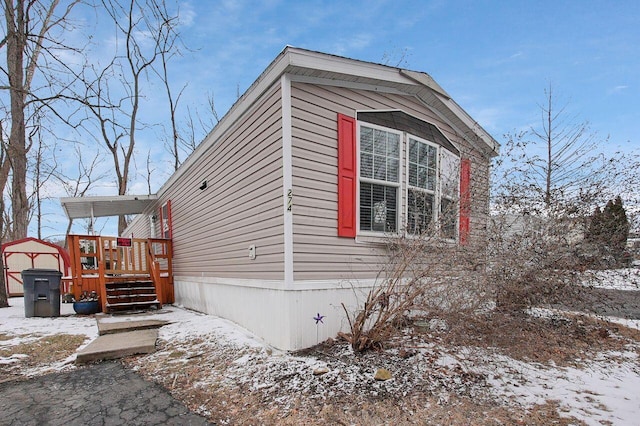 view of snowy exterior with a wooden deck