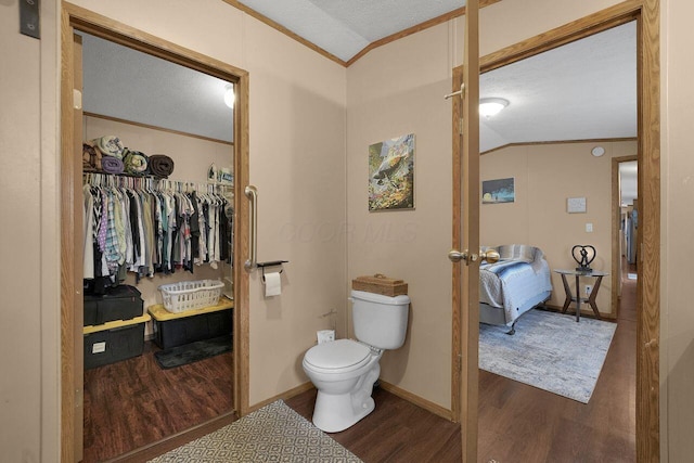 bathroom featuring lofted ceiling, a textured ceiling, wood finished floors, and crown molding