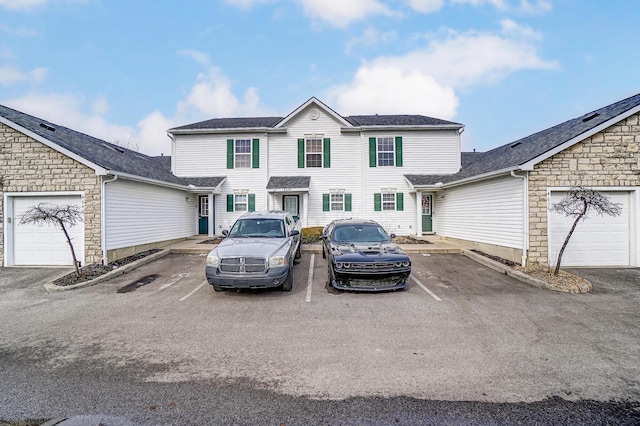 view of front of home featuring uncovered parking and roof with shingles