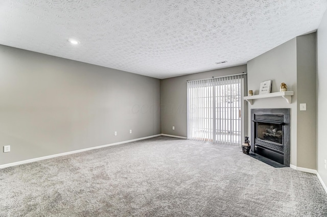 unfurnished living room with a fireplace with flush hearth, a textured ceiling, baseboards, and carpet flooring